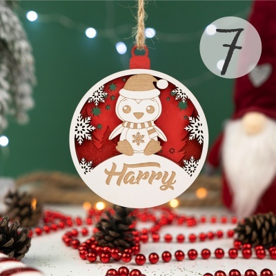 Enfeite de Natal redondo em madeira com pinguim vestido com gorro e cachecol e texto Happy