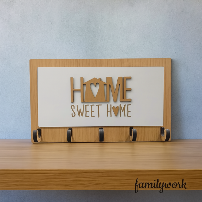 Cabideiro em madeira clara com cinco ganchos pretos e texto decorativo HOME SWEET HOME.