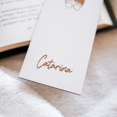 Marcador de livros branco com nome Catarina e desenho de rosto com cabelo castanho e óculos