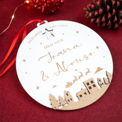 Enfeite redondo de Natal branco com nome personalizado e decoração tridimensional em MDF, fita vermelha para pendurar.