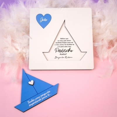 Cartão com texto personalizado sobre penas brancas e envelope azul em fundo rosa.