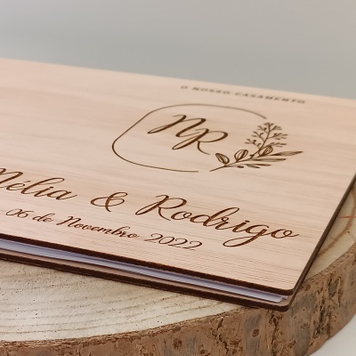 Livro de capa de madeira clara gravada com texto sobre casamento
