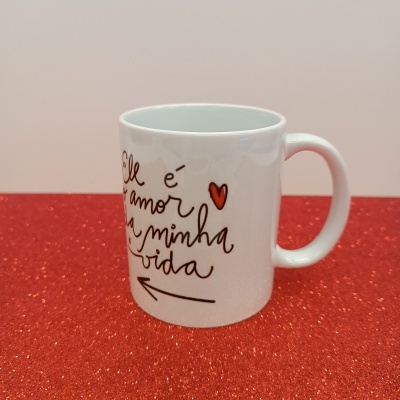 Caneca branca com texto e coração vermelho em superfície vermelha brilhante