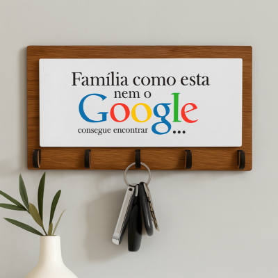 Suporte de chaves em madeira com texto colorido na placa e vaso branco com folha verde ao lado