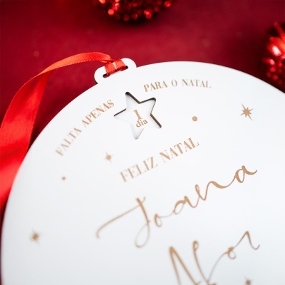 Adorno de Natal branco redondo com fita vermelha e texto dourado