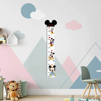 Medidor de altura infantil Mickey Mouse com nome e data, parede decorada com montanhas e nuvens coloridas.