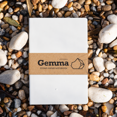 Caderno branco Gemma com faixa castanha sobre pedras e folhas secas