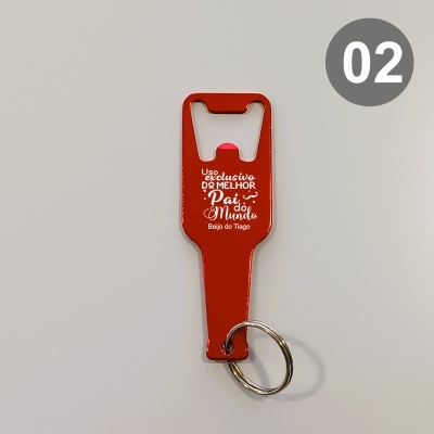 Chaveiro abridor de garrafas vermelho com texto branco e argola metálica sobre fundo cinza.