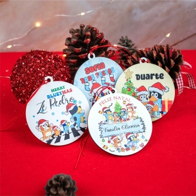 Etiquetas de Natal personalizadas redondas com desenhos de personagens e nomes em fundo vermelho com pinhas e luzes.