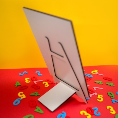 Traseira de monitor branco sobre superfície vermelha com números coloridos e fundo amarelo