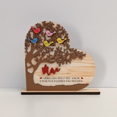 Placa decorativa de madeira em forma de coração com árvore e pássaros coloridos e texto dedicado à mãe.