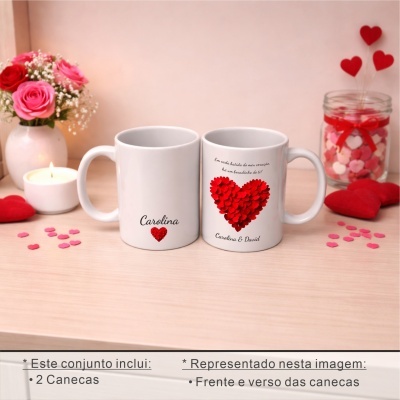 Conjunto de duas canecas brancas com corações vermelhos e texto em português, decoradas com flores, vela e corações vermelhos.