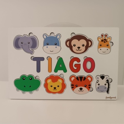 Jogo de madeira com peças de animais e letras a formar o nome TIAGO.