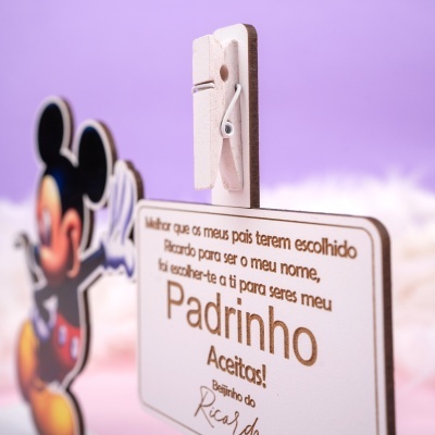 Prendedor de roupa branco de madeira com placa de madeira e personagem colorida ao fundo