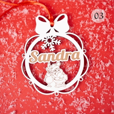 Enfeite de Natal branco em MDF com laço e neve, texto Sandra, fita vermelha e fundo vermelho com neve artificial.