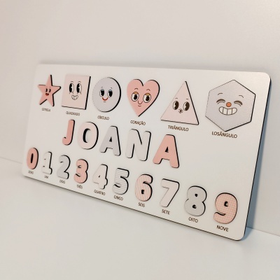 Quadro branco com peças em madeira e formas geométricas e números sorridentes em tons rosa e branco.