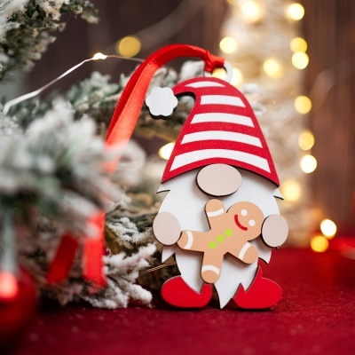 Boneco decorativo natalício em madeira com chapéu às riscas vermelhas e brancas segurando um boneco de gengibre.