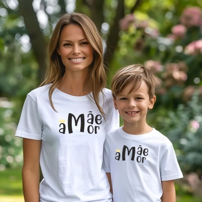 Camisetas brancas com texto preto e amarelo a Mãe Or usadas por mulher e menino em ambiente exterior