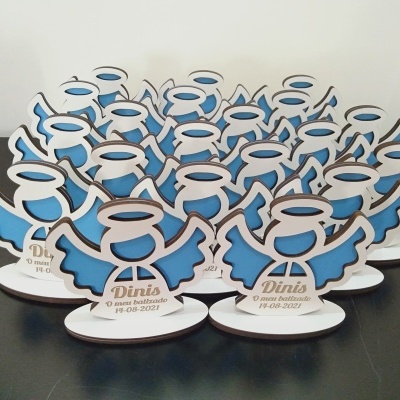 Figura decorativa em forma de anjo azul e branco com texto na base sobre superfície preta