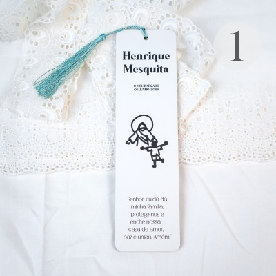 Etiqueta de batizado branca com tassel azul, texto preto e tecido rendado branco ao fundo