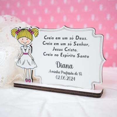 Placa decorativa em madeira com figura de menina e texto religioso em português