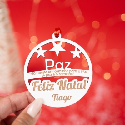 Enfeite de Natal branco redondo com texto e estrelas, fundo vermelho