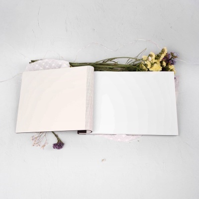 Livro aberto de páginas em branco com flores secas em fundo branco