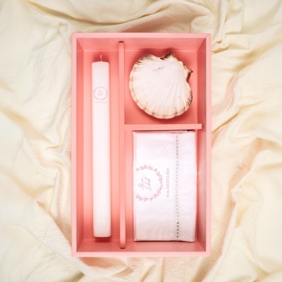 Conjunto em caixa rosa com vela branca, concha natural e pano branco bordado