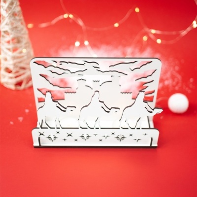 Decoração branca em metal com recortes de camelos, estrelas e morcegos sobre fundo vermelho com luzes