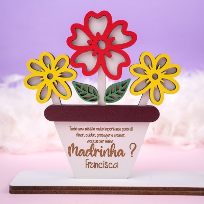 Objeto decorativo em madeira com flores coloridas e texto personalizado em português