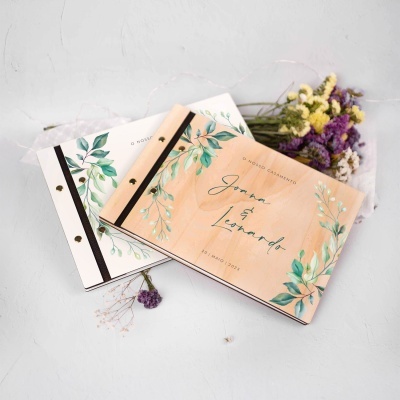Álbuns de casamento com capas decoradas com folhas verdes e texto com nomes Joana e Leonardo e data 20 Maio 2023