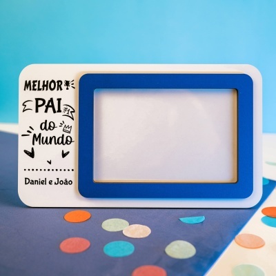 Moldura de fotografia em madeira branca e azul com texto personalizado e confetes coloridos em fundo azul.
