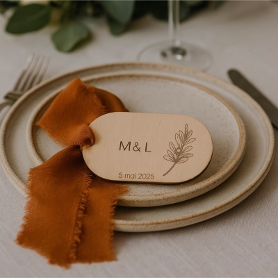 Mesa posta com pratos cerâmicos, guardanapo laranja e placa de madeira gravada