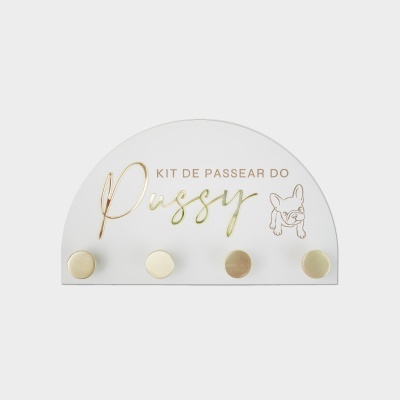 Placa semicircular branca com 4 ganchos dourados e texto KIT DE PASSEAR DO Pussy junto a desenho de cão