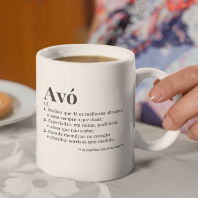Caneca branca com texto em português Avó sobre toalha branca e mão segurando a alça.