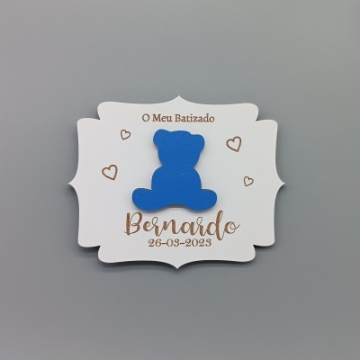 Cartão de papel branco com ursinho azul e texto em castanho sobre batizado