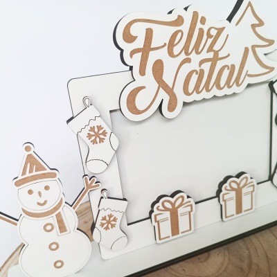 Decoração natalícia branca em madeira com gravuras castanhas e frase FELIZ NATAL