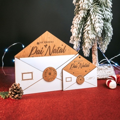 Dois envelopes de Natal com abas de madeira gravada e selo de madeira em fundo vermelho com decoração natalícia.