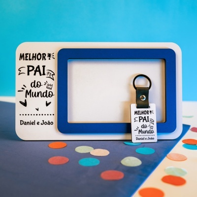 Moldura fotográfica branca com detalhe azul e chaveiro preto com texto dedicatória a pai.