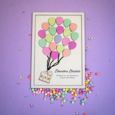 quadro decorativo com balões de madeira coloridos e casas penduradas com texto em fundo branco