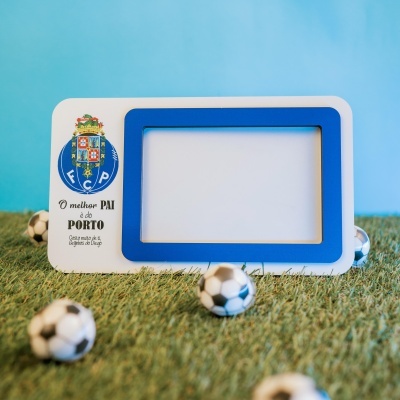 Moldura de fotografia com emblema do FC Porto e texto sobre relva artificial com bolas de futebol