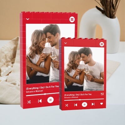 Molduras de fotos vermelhas tipo Lego com foto de casal e texto de música visível.