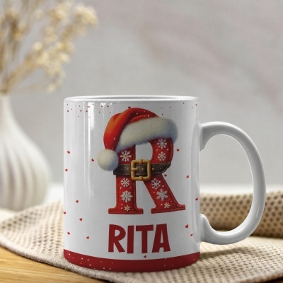 Caneca branca com letra R natalícia e nome Rita em vermelho.
