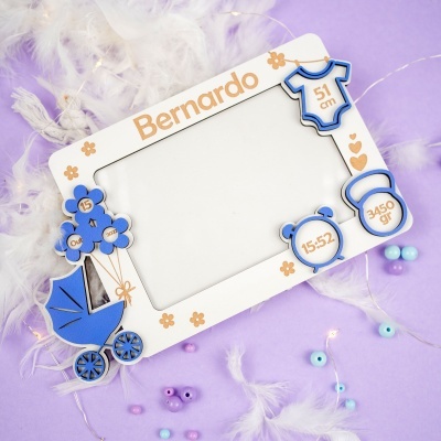 Moldura decorativa branca e azul com dados de bebé e fundo lilás com penas e contas.
