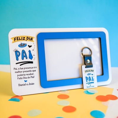 Chaveiro para o Dia do Pai com frase de felicitação em moldura branca e azul sobre fundo amarelo com confetes.