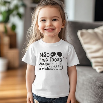 Menina sorridente com camisola branca estampada com texto e óculos escuros num ambiente interior