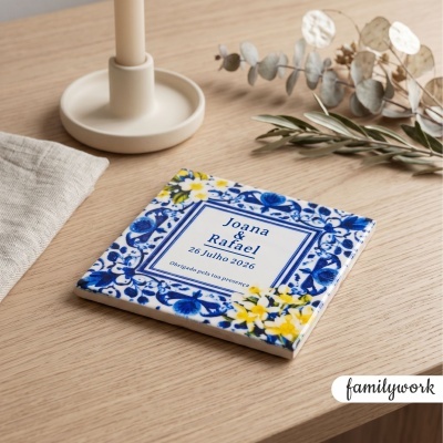 Azulejo decorativo de cerâmica com padrão floral azul e amarelo e texto azul em superfície de madeira clara