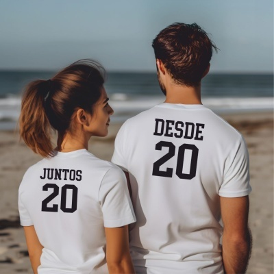 Casal na praia de t-shirts brancas com texto nas costas