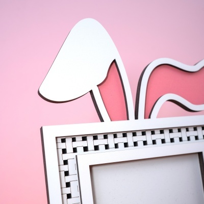 Moldura de fotografia branca com padrão geométrico e orelha de coelho rosa e branca