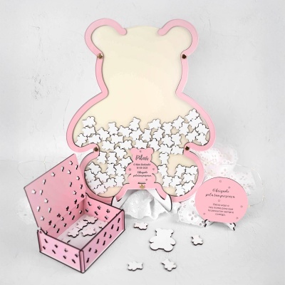 Quadro em forma de urso com moldura rosa e pequenos ursinhos de madeira brancos